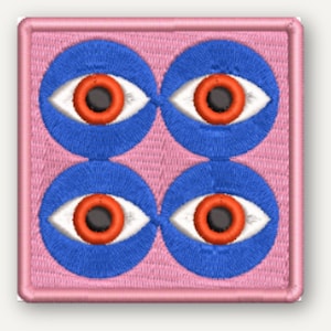 Könnte beinhalten: Ein quadratischer Stickaufnäher mit hellrosa Hintergrund und einem Rand in derselben Farbe. Das Design besteht aus vier kreisförmigen blauen Formen, die jeweils ein weißes Auge mit leuchtend orangefarbener Iris und schwarzer Pupille zeigen.