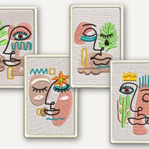 Puede incluir: Un conjunto de cuatro parches rectangulares bordados con diseños de rostros abstractos. Cada parche muestra rasgos faciales estilizados en hilo negro, acentuados con bordados en color melocotón, verde, azul y amarillo sobre tela gris claro.