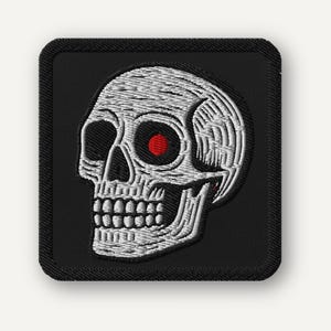 Parche bordado de calavera con ojo rojo brillante, termoadhesivo o con velcro.