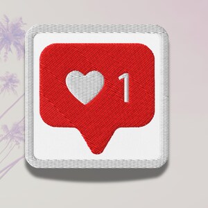 Flat lay of Micro Influencer patch iron-on with red Instagram heart icon, 1 Like text, on neutral background, showing crisp embroidery and playful self-deprecating humor, perfect for jackets, backpacks, or gifts.
