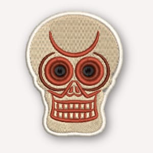 May include: An embroidered patch shaped like a skull with a beige base and red thread detailing. The design features circular red eye sockets with black centers, a red nose outline, and a wide red mouth with visible teeth and a curved brow line.