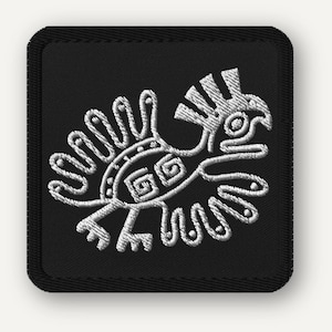 May include: A square black embroidered patch featuring a white stitched graphic of a stylized bird with a crested head, curved wings, and geometric spiral patterns on its body. The patch has a thick black border with a visible stitched edge.