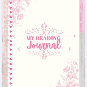 May include: A cream-coloured reading journal with pink floral designs and a spiral binding. The cover displays the text "MY READING Journal" in pink script, with decorative flourishes. Tabs on the right are labelled "Library", "Book of the Month", "Book Reviews", and "Reading Goal".