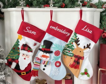 May include: Three Christmas stockings with red tops and white bodies hang from a fireplace. One stocking has "Sam" embroidered on it, another says "embroidery", and the third says "Lisa". Each stocking features festive designs like Santa, a snowman, and a reindeer.