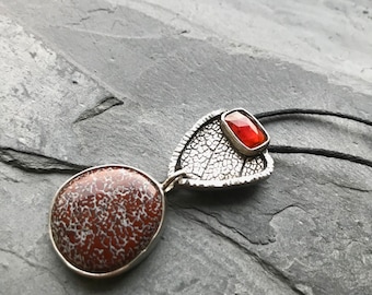 Red dinosaur bone pendant in sterling silver with hessonite garnet