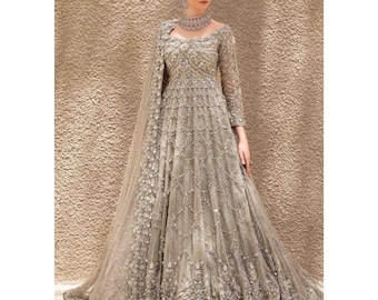 May include: A long, flowing, silver-gray gown with intricate beadwork and embroidery. The dress features long sleeves, a high neckline, and a full skirt. A matching shawl and a beaded choker complete the elegant ensemble, perfect for formal events.
