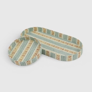 Pode incluir: Um conjunto de duas bandejas, uma circular e outra oval alongada, com um padrão de riscas azul-claro e creme com pequenos motivos florais castanhos. As bandejas têm bordos elevados e um design repetitivo consistente.