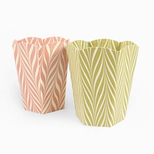May include: Two decorative paper containers with scalloped edges. One is pink with a cream-coloured leaf pattern, and the other is green with a cream-coloured leaf pattern. The containers have a hexagonal base.