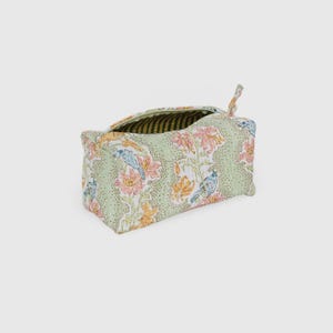 May include: A rectangular, open-top fabric storage bag with a floral and bird pattern. The bag features a light green background with pink, orange, and blue floral and bird designs. The interior lining has a striped pattern.