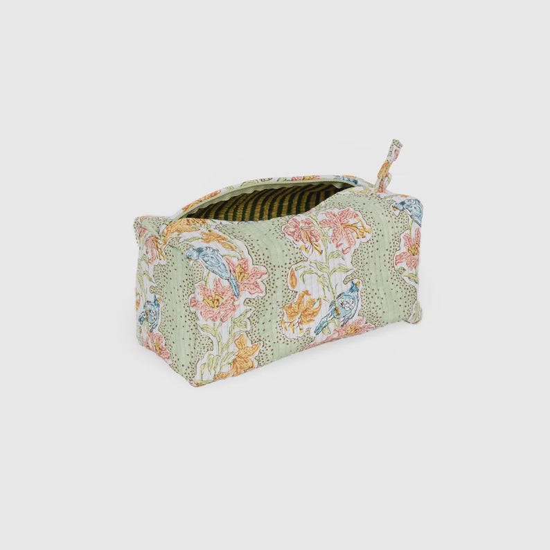 May include: A rectangular, open-top fabric storage bag with a floral and bird pattern. The bag features a light green background with pink, orange, and blue floral and bird designs. The interior lining has a striped pattern.