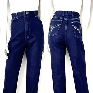 K&ouml;nnte beinhalten: Dunkelblaue Jeans aus Denim mit hohem Bund und geradem Bein. Die Jeans hat wei&szlig;e N&auml;hte und dekorative N&auml;hte auf den Ges&auml;&szlig;taschen. Die Jeans wird auf einer Schaufensterpuppe pr&auml;sentiert.