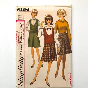 May include: Vintage Simplicity sewing pattern featuring three illustrated women in 1960s-style outfits. The pattern includes a green jumper, a plaid skirt and vest, and a gold top with a patterned skirt. The pattern number is 6184, size 12, bust 32.