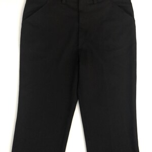 May include: A pair of black dress pants with a classic, straight-leg design. The pants feature front pockets, belt loops, and a button and zipper closure. The fabric appears to be a smooth, solid black, suitable for formal or professional wear.