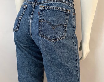 May include: Blue denim jeans with a classic five-pocket design. The jeans feature a Levi Strauss & Co. label on the back waistband. The jeans are displayed on a mannequin.