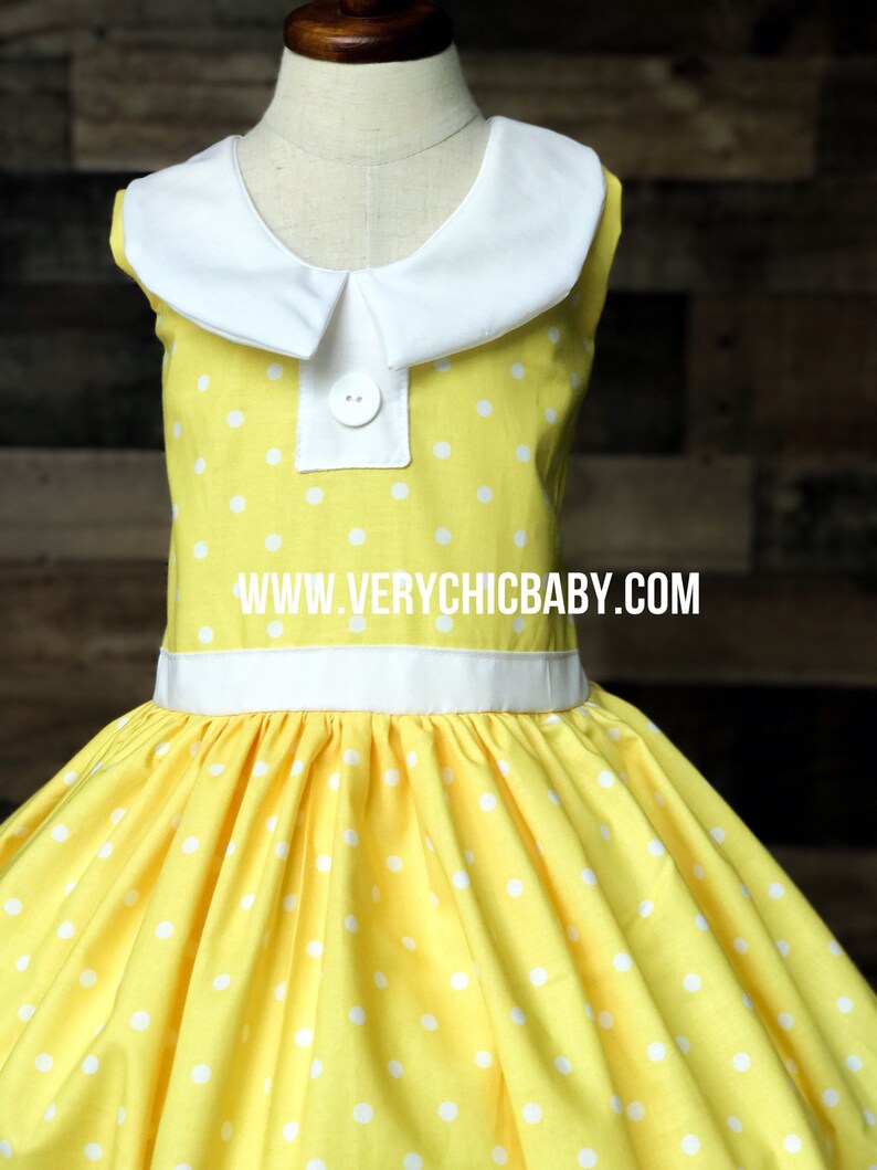 May include: A yellow sleeveless dress with white polka dots and a white Peter Pan collar. The dress has a white sash around the waist and a button closure at the neckline. The dress is made of a soft, comfortable fabric and is perfect for a special occasion. www.verychicbaby.com