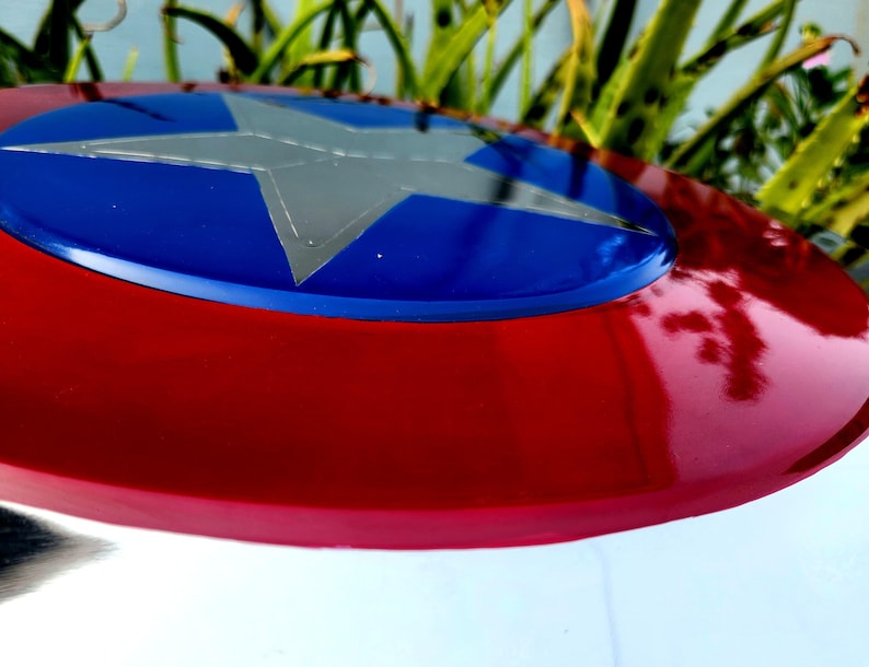 May include: A red, white and blue Captain America shield with a silver star in the centre.