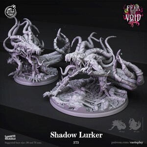 May include: Two light gray Shadow Lurker miniature figures featuring elongated limbs, sharp teeth, and multiple tentacles. The creatures are posed on circular bases with a cracked ground texture. Text includes Cast n Play, Fear the Void, and 575.