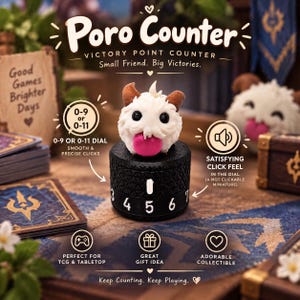 Könnte beinhalten: Ein schwarzer, zylindrischer Siegpunktzähler mit einer weißen, flauschigen Poro-Figur mit braunen Hörnern und einer rosa Zunge obenauf. Das Zifferblatt zeigt weiße Zahlen und den Text Poro Counter, Victory Point Counter, Small Friend. Big Victories.