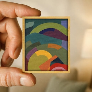 Può includere: Un dipinto rettangolare in miniatura in una cornice di legno chiaro che presenta una composizione astratta di forme geometriche e linee curve sovrapposte in tonalità verde oliva, ottanio, viola scuro, giallo senape, arancione e rosso vivo.