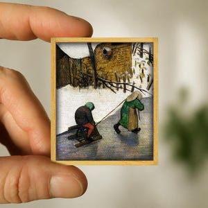 Op de afbeelding: Een miniatuur schilderij in een lijst dat een winters tafereel toont. Twee figuren zijn aanwezig: een op een slee, getrokken door een ander. Het schilderij, in een houten lijst, toont een besneeuwd landschap met gebouwen.