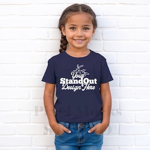 May include: A young person wearing a navy blue t-shirt with the text "Your StandOut Design Here" in white. The shirt has a small floral design above the text.