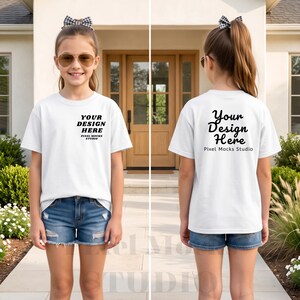 May include: A white short-sleeve t-shirt featuring black text on the front left chest that reads YOUR DESIGN HERE PIXEL MOCKS STUDIO and larger black text on the back that reads Your Design Here Pixel Mocks Studio, paired with blue denim shorts.