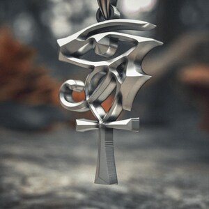 Side angle view of sterling silver Egyptian pendant showcasing the three-dimensional craftsmanship with polished surfaces of the Wadjet eye and Ankh.