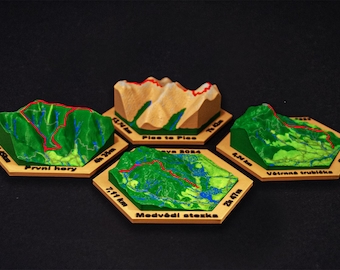 May include: Four miniature mountain models with green, tan, and red details, each mounted on a hexagonal wooden base. The models feature topographical details and text labels, including distance and time.