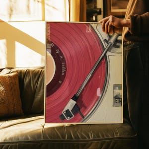 May include: Framed art print featuring a close-up of a vintage record player with a red vinyl record. The text "All of a Sudden" is printed on the record. The artwork has a warm, inviting color palette and is set in a gold frame.
