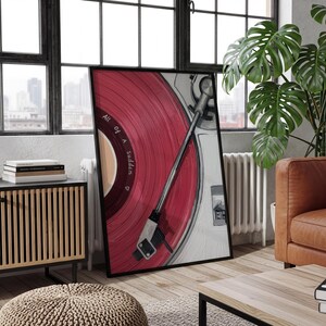 May include: Framed artwork featuring a close-up of a vintage record player with a red vinyl record. The record player is set against a white and gray background, with the text "All of a Sudden" visible on the record. The artwork is in a black frame.