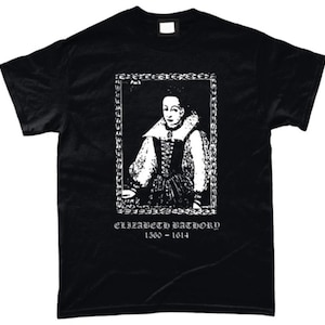 Op de afbeelding: Zwart T-shirt met een wit portret van Elizabeth Báthory in een decoratieve lijst. De tekst "ELIZABETH BATHORY 1560 - 1614" staat eronder. Het T-shirt heeft een ronde hals.