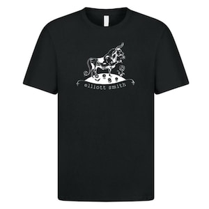 May include: Black t-shirt with a white illustration of a bull, flowers, and the text "elliott smith". The shirt has a crew neck and short sleeves. The design is centrally placed on the front of the tee.