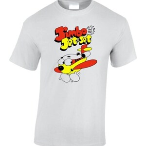 May include: White t-shirt featuring a cartoon airplane with the text "Jimbo Jet Set." The airplane is yellow with red wings and a smiling face. The text is in red and yellow.
