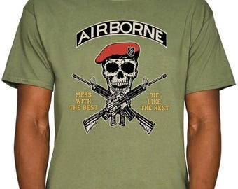 May include: Olive green t-shirt with a graphic featuring a skull wearing a red beret, crossed rifles, and the word "AIRBORNE". Text below reads "MESS WITH THE BEST" and "DIE LIKE THE REST".