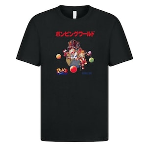 May include: Black t-shirt with a vibrant graphic design and Japanese text. The design features cartoon characters, a globe, and the word "Pang". The shirt has a classic crew neck and short sleeves.