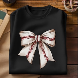 May include: Black sweatshirt with a white bow design. The bow is made of baseball stitching with red stitching.