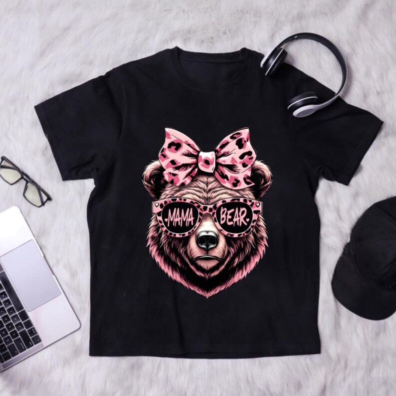 Pu&ograve; includere: Maglietta nera con un orso rosa che indossa occhiali da sole che dicono "Mama Bear" e un fiocco rosa con stampa leopardata.