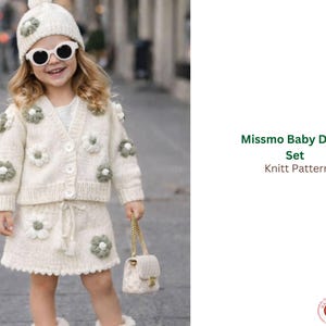 May include: A cream knitted baby set with daisy appliqués. The set includes a cardigan, skirt, and hat, all decorated with green and cream-coloured flower details. The outfit is worn with a small purse and sunglasses. The text "Missmo Baby Daisy Set Knitt Pattern" is visible.