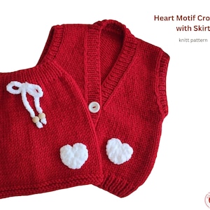 May include: A red knitted crop vest and skirt set with white heart appliqués. The vest has a V-neck and a button closure. The skirt has a drawstring with wooden beads. The text "Heart Motif Crop Vest with Skirt" is visible.