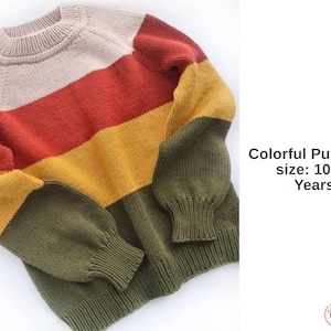 Può includere: Un maglione colorato con strisce orizzontali beige, rosse, gialle e verde oliva. Il maglione ha maniche lunghe e scollatura a coste. Il testo sull'immagine dice "Colorful Pull-over size: 10-12 Years".