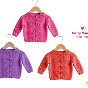 May include: Three knitted baby cardigans in shades of pink, purple, and orange, each with a button-up front and a cable knit design. The cardigans are displayed on wooden hangers against a white background. Text on the right reads "Marry Cardigan Knitt Pattern."