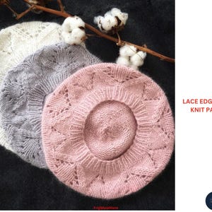May include: Three knitted berets in white, gray, and pink, with a lace edge design. The berets are arranged on a dark surface with cotton branch accents. Text on the right reads "LACE EDGE BERET - KNIT PATTERN".