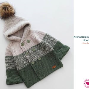 May include: A knitted beige and green hoodie with a hood and a faux fur pom-pom. The sweater has a button-up front and is made of soft, textured yarn. The design includes stripes and a small leather tag.
