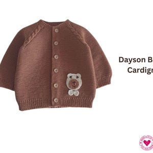 Op de afbeelding: Een bruin gebreid vest met een berenapplicatie. De trui met knopen heeft lange mouwen en een ronde halslijn. De tekst "Dayson Bear Cardign" wordt aan de rechterkant van de afbeelding weergegeven.