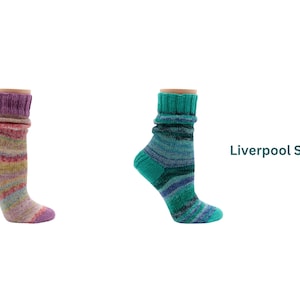 Può includere: Due calzini colorati lavorati a maglia. Uno ha polsino e tallone viola con strisce rosa, gialle e blu. L'altro ha polsino e tallone turchese con strisce blu e verdi. Il testo "Liverpool Socks" è a destra.