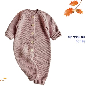Puede incluir: Un pelele para bebé de color rosa polvoriento con un diseño de punto texturizado. El pelele de manga larga tiene una botonadura frontal y puños y tobillos acanalados. El texto "Marida Fall Romper for Baby" es visible.