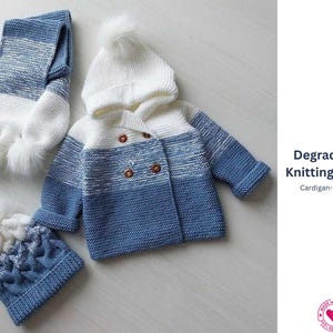 May include: A knitted baby set in white and blue, including a hooded jacket with wooden buttons, a matching hat with a pom-pom, and a scarf with pom-poms. The set features a color gradient design. The text "Degradé Set-Knitting Pattern" is visible.