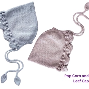 May include: Two knitted baby bonnets in light blue and mauve. Each bonnet features a decorative edge with bobbles and a vine-like pattern. The bonnets have long ties with leaf-shaped ends. The text "Pop Corn and Vine Leaf Cap" is visible.
