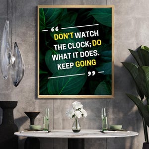 May include: A framed motivational quote on a green leafy background. The quote reads "Don't watch the clock; do what it does. Keep going."