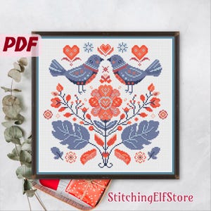 Oiseaux de la Saint-Valentin au point de croix de style folklorique. Broderie ukrainienne festive avec des fleurs roses. Belle carte des fêtes. Cadeau pour elle